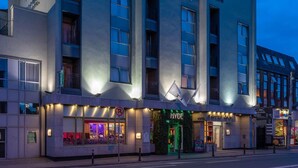 A modern hotel with a prominent entrance, multiple windows, and a visible sign for a restaurant. - Hyde Hotel (Galway)
