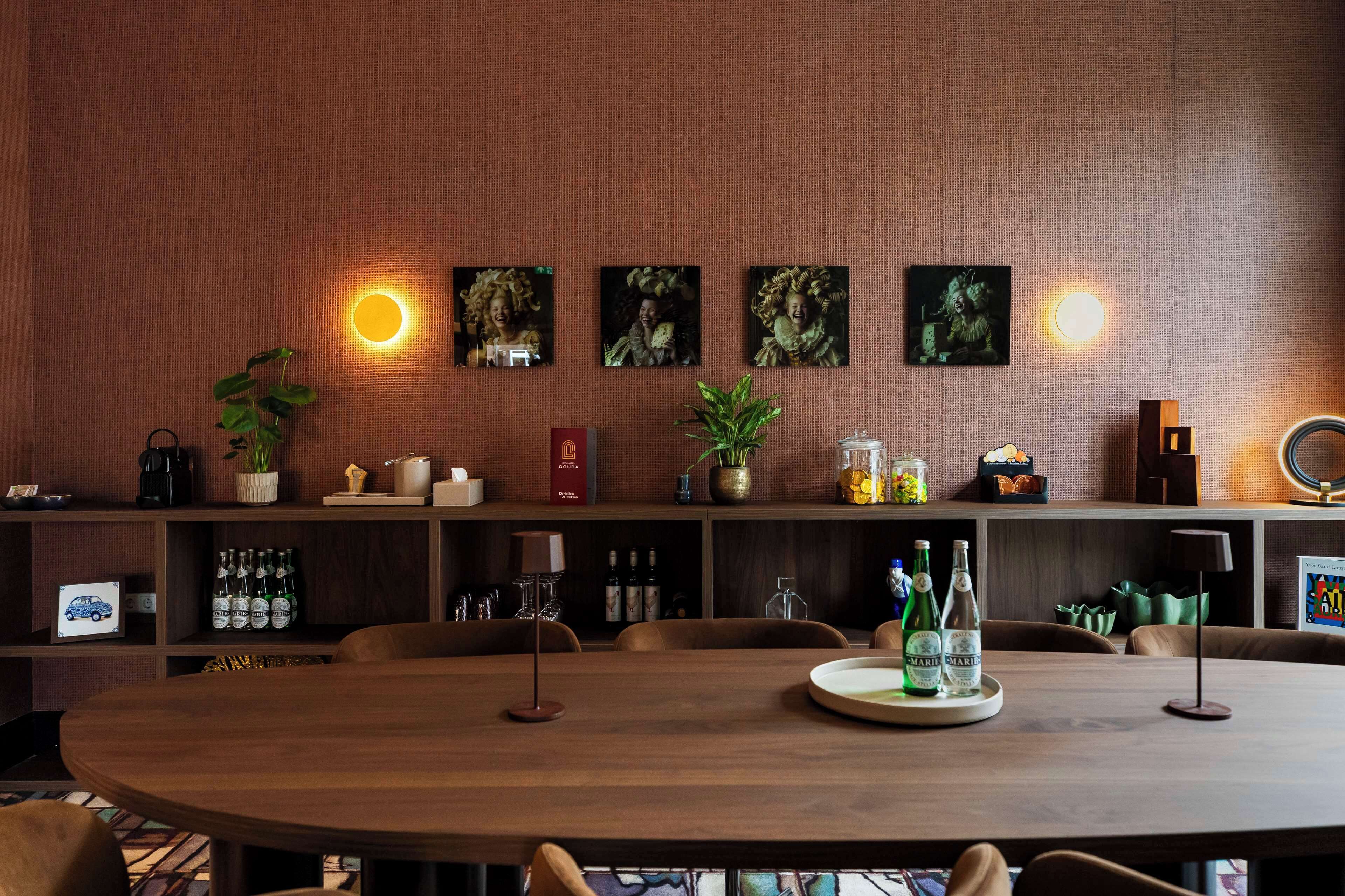 Un comedor con una mesa de madera, sillas y una estantería con diversos objetos, incluyendo botellas y un libro.