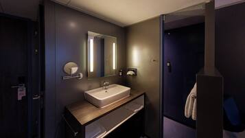 Un baño moderno con un espejo grande, un lavabo y un perchero para toallas.
