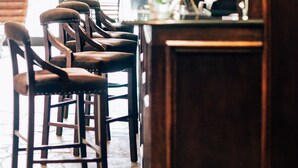 Een barruimte met houten stoelen en een centrale bar.