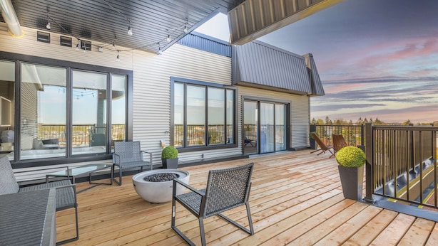A spacious outdoor deck with seating, a fire pit, and potted plants.