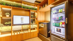A well-lit room with wooden shelving, a television, and a beverage vending machine.