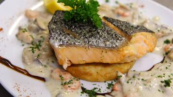 A plate of salmon with a creamy sauce, garnished with parsley.