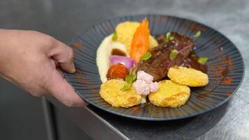 A plate of food with various items including a piece of meat, vegetables, and breaded items.