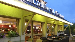 An outdoor seating area of L'Atelier 117 Restaurant with tables and chairs. - Best Western l'Atelier 117 (Maubeuge)