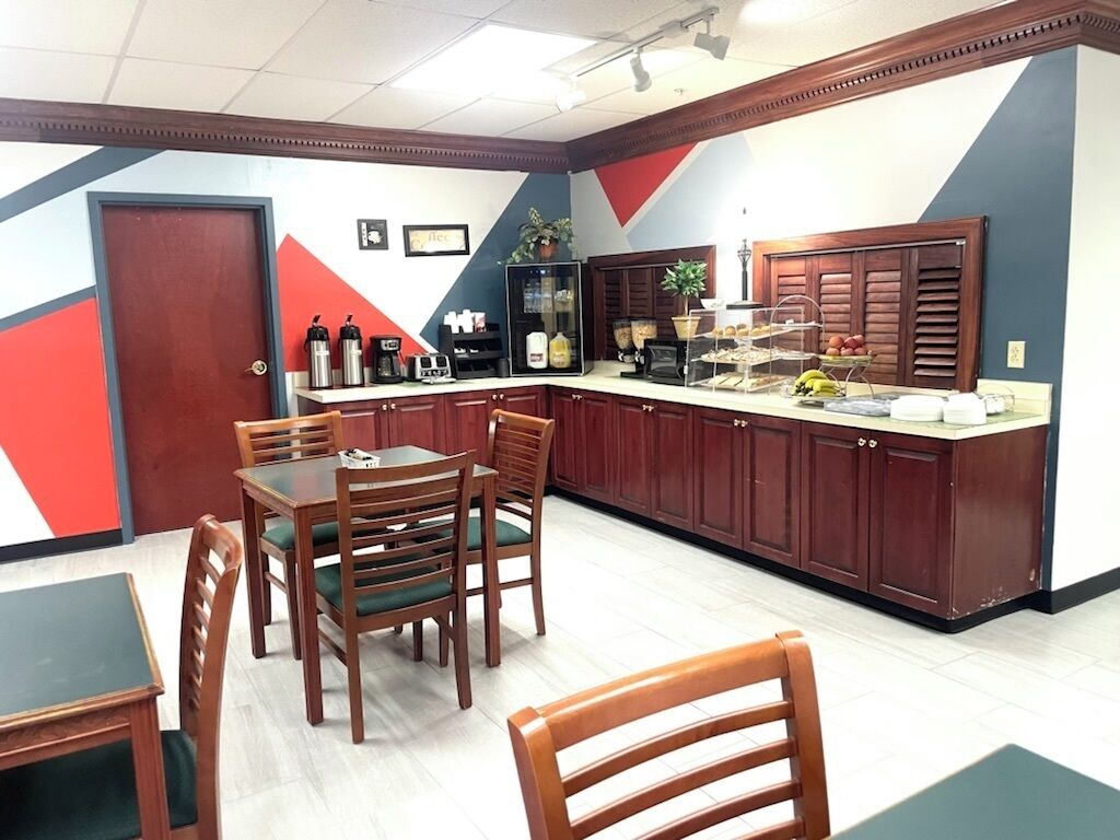 A dining area with a counter, chairs, and a table.