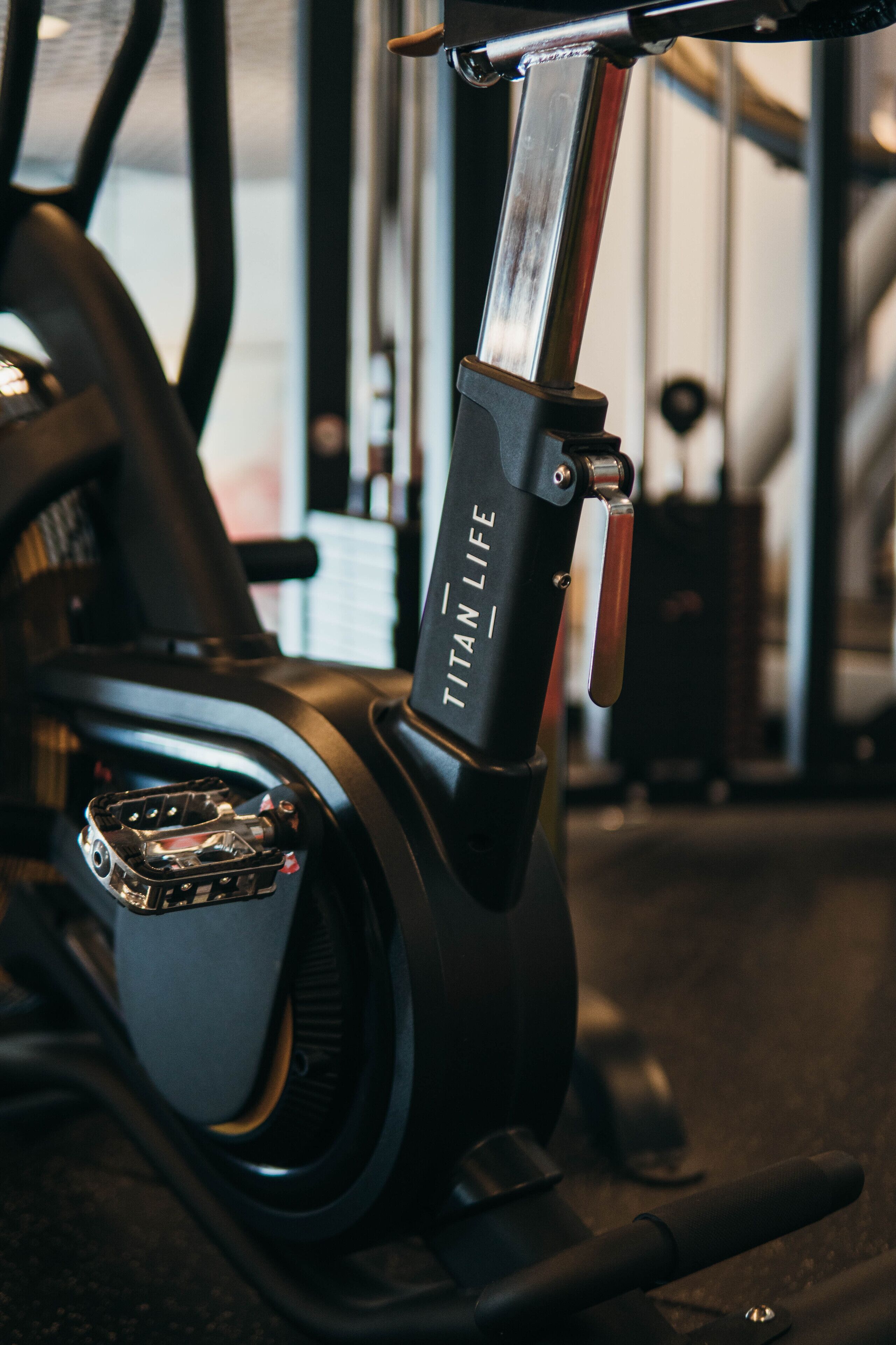 A stationary exercise bike with the brand name "Titan Life" visible on the handlebar.