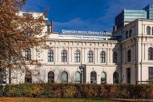 The Comfort Hotel Grand Central building with classical architecture, large arched windows, and a prominent sign.