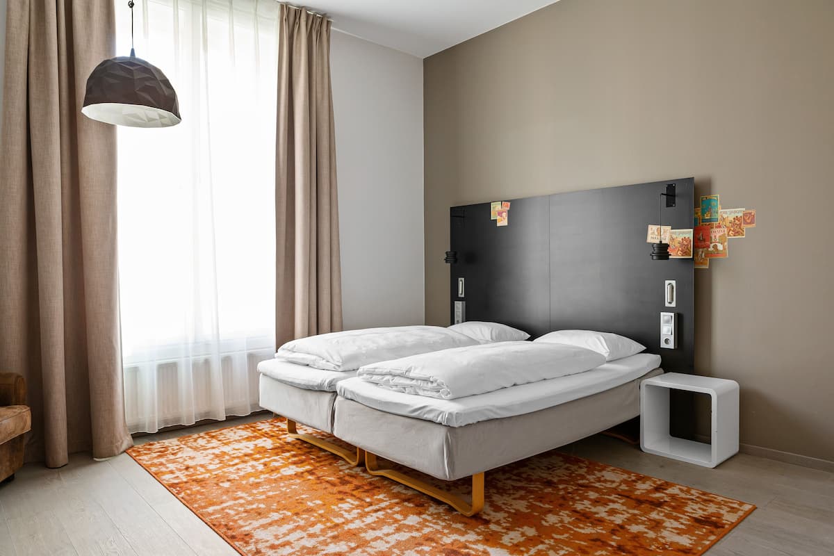 Una camera da letto moderna con un letto, un comodino, una lampada e una finestra con tende.