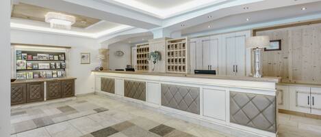 A spacious kitchen with a long island, built-in cabinets, and a chandelier.