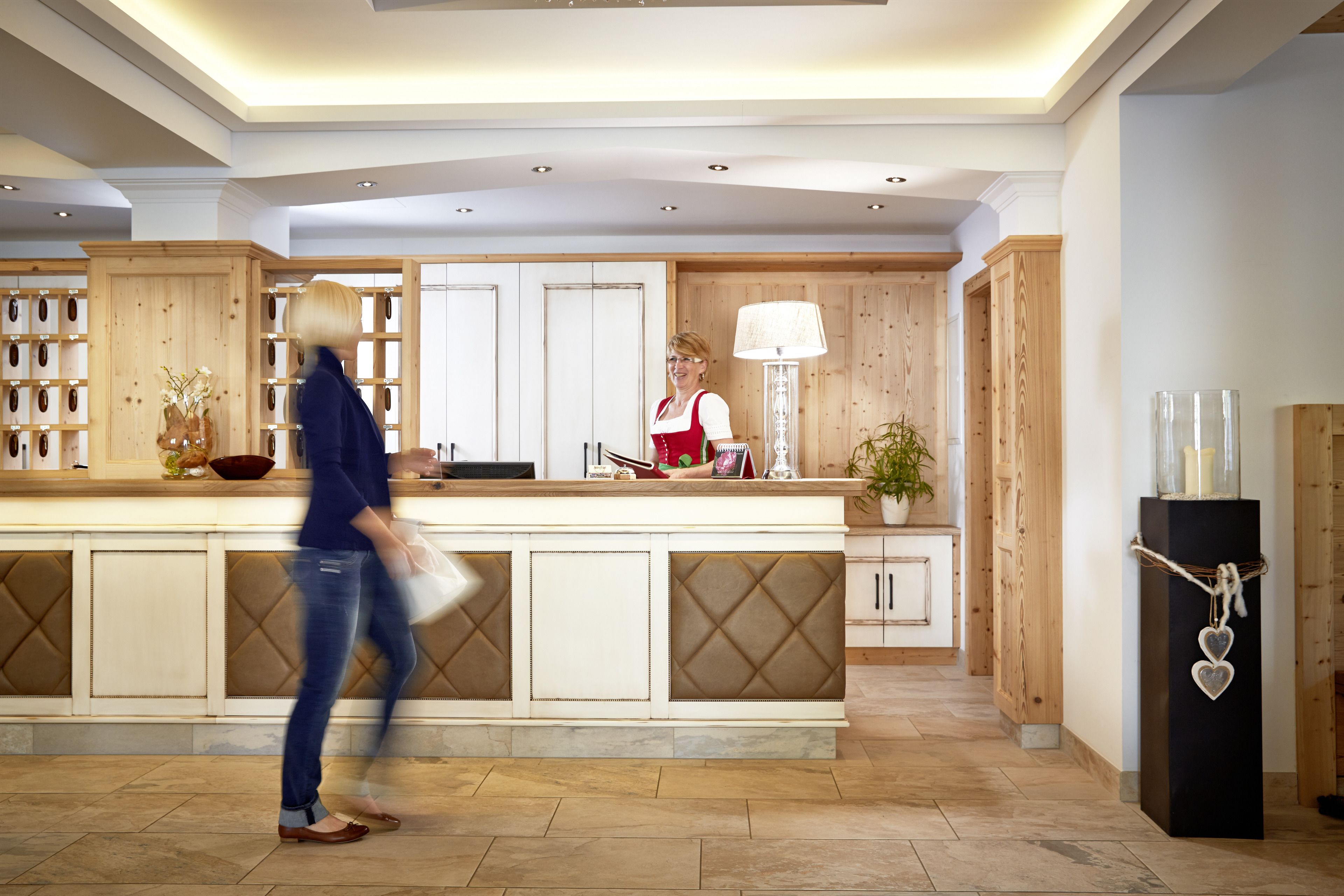A modern kitchen with a central island, wooden cabinetry, and a potted plant.