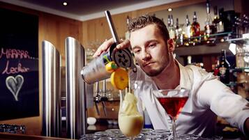 A bartender pouring a drink into a glass.