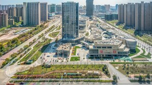 Una zona urbana moderna amb edificis alts, una plaça central i un traçat de carretera corbat.