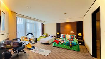 A hotel room with a bed, a desk, a chair, a small table, and a window.
