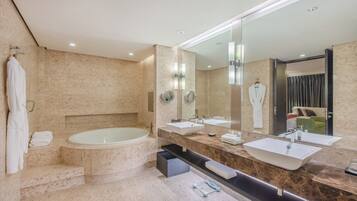 A modern bathroom with a large bathtub, two sinks, and a large mirror.