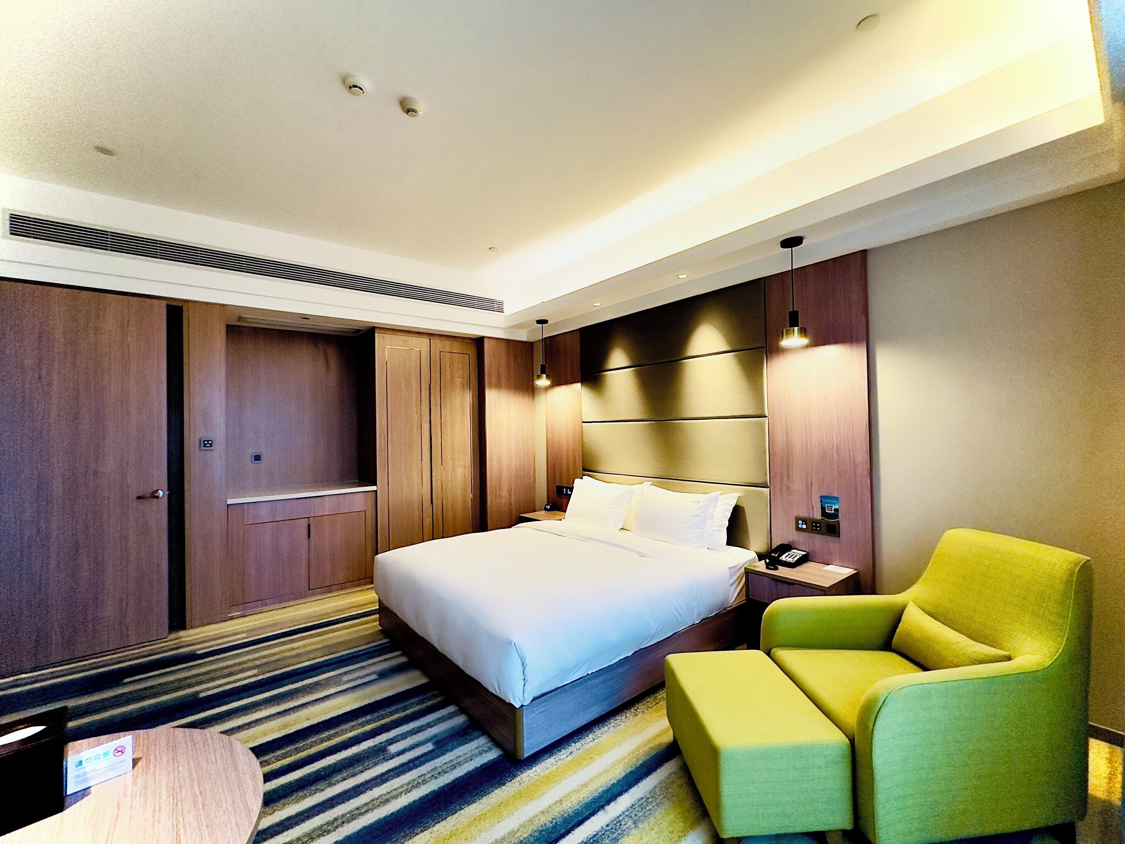 Una habitación de hotel con una cama, un escritorio, una silla y piso alfombrado.