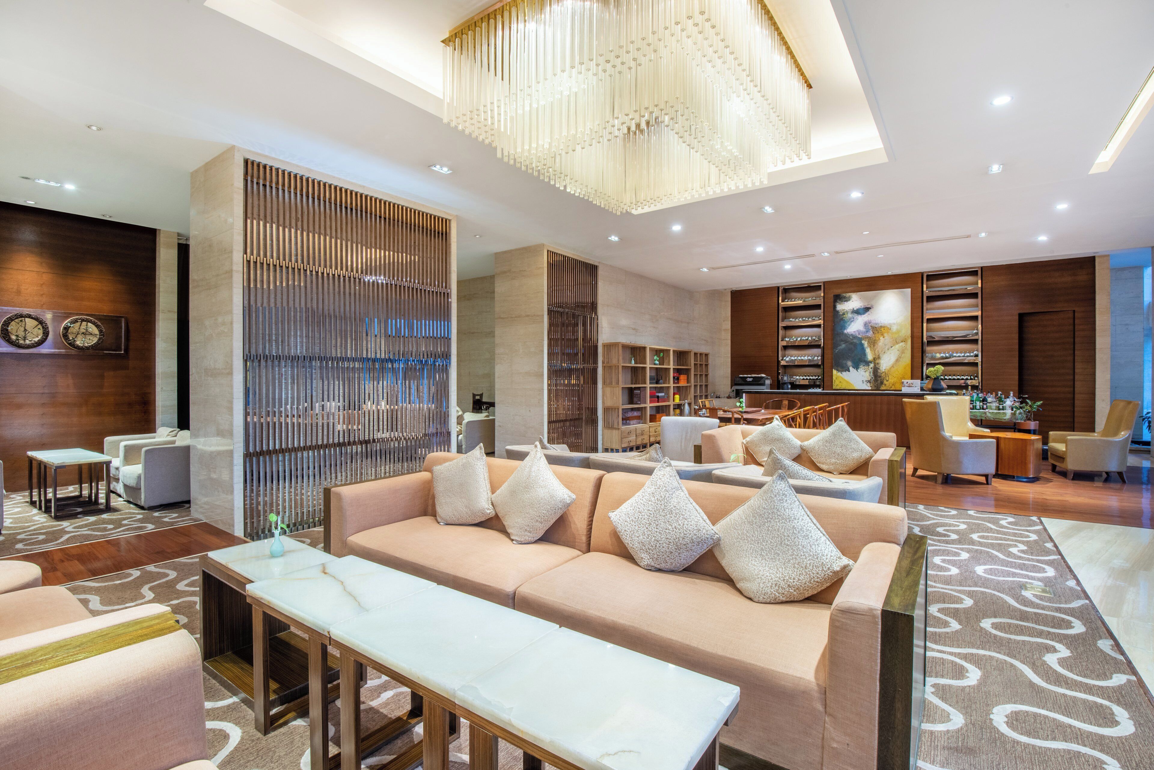 A modern lobby with a seating area, a reception desk, and a bar.