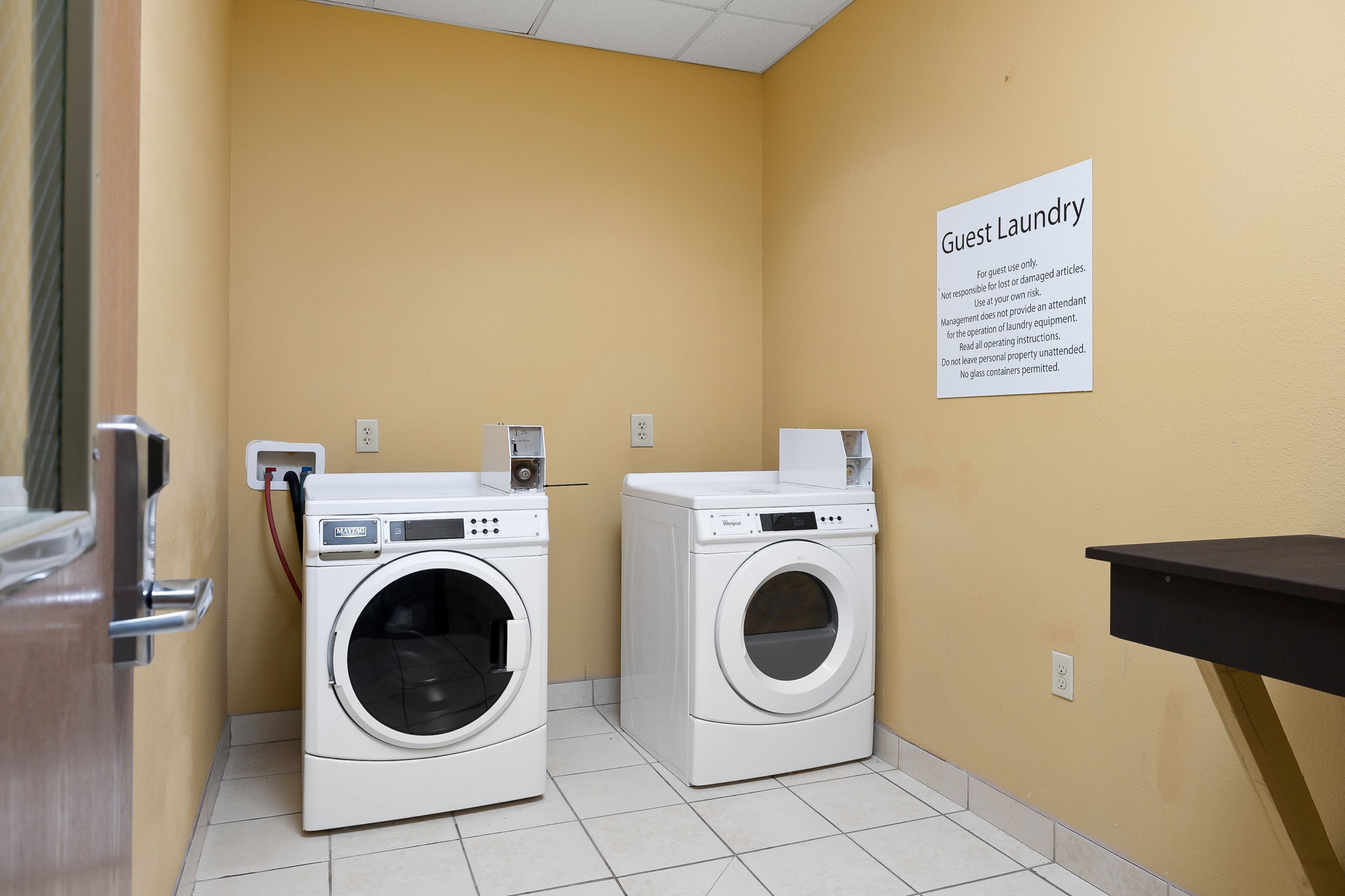 A guest laundry area with two washing machines and a sign detailing usage instructions.