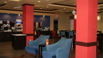 Una hall d'albergo con zona bar, posti a sedere e reception.