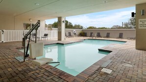 A swimming pool with a brick deck, lounge chairs, and a lifeguard stand. - Holiday Inn Express and Suites George West by IHG (George West)