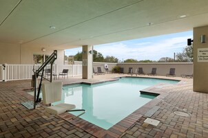 Una piscina al aire libre, sillones reclinables de piscina