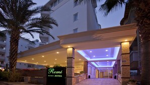 Entrada de hotel con un cartel que dice "Remi Hotel" y un corredor cubierto que lleva a la entrada.