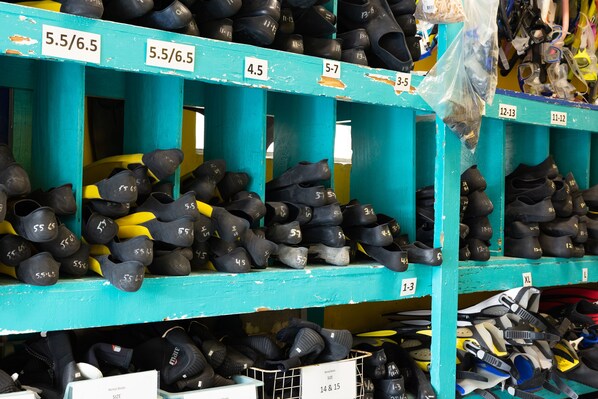 A shoe rental booth with multiple shelves labeled with sizes and prices. - Looe Key Reef Resort (Summerland Key)