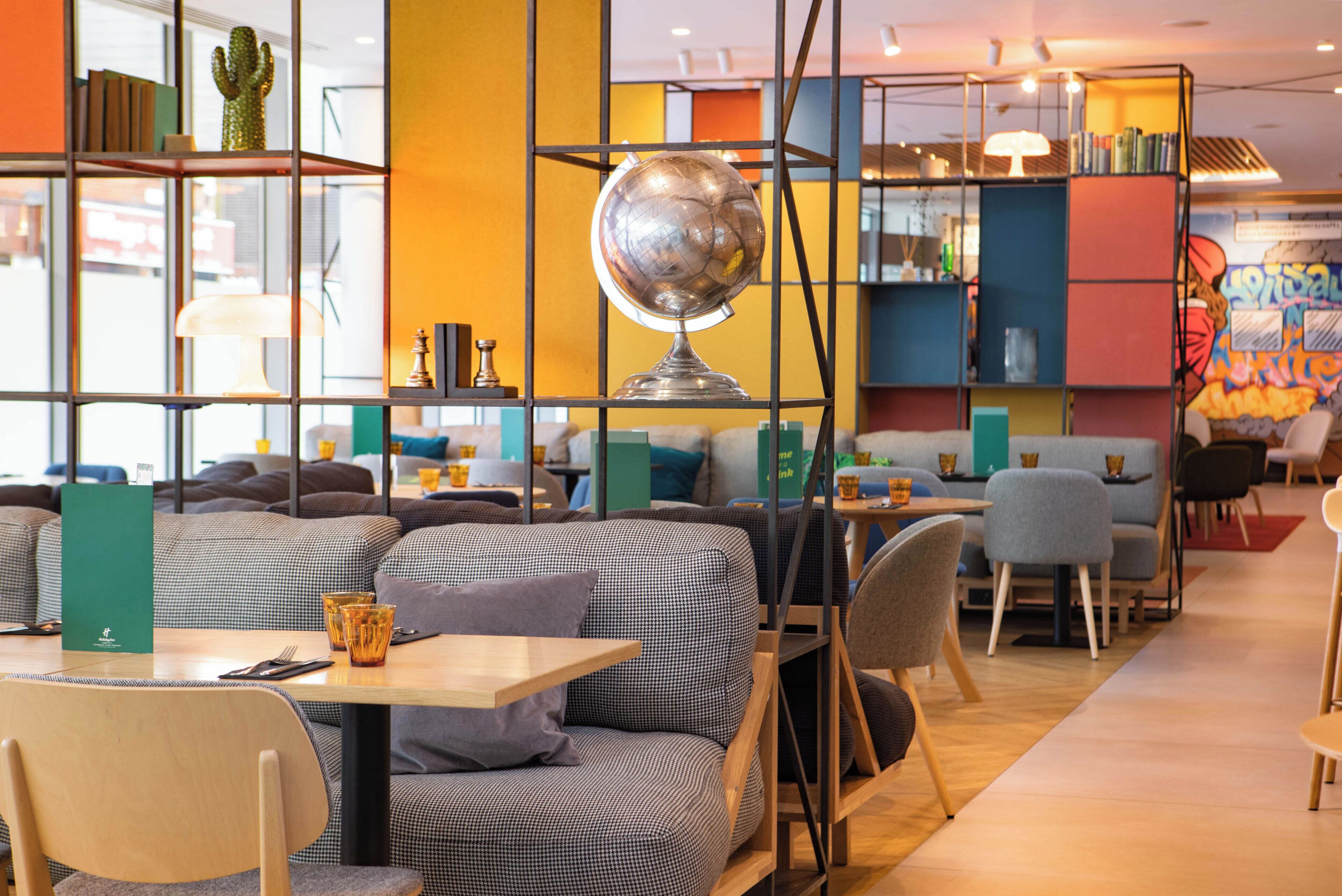 A modern interior with seating areas, a globe decoration, and bookshelves.