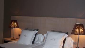 A hotel room with a large bed, two bedside lamps, and a headboard.