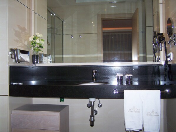 A modern bathroom with a black sink, a glass shower enclosure, and a large mirror. - Washington Parquesol Suites & Hotel (Valladolid)