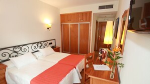 A bedroom with a bed, a desk, a chair, a wardrobe, and a mirror. - La Bodega Hotel (Ciudad Rodrigo)