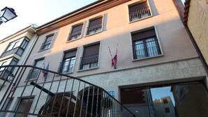 A multi-story building with a balcony, a large wheel, and a flag. - La Bodega Hotel (Ciudad Rodrigo)