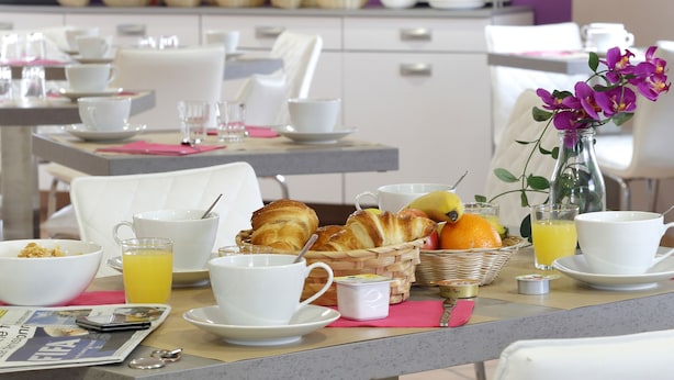 A breakfast setting with tables, chairs, and various breakfast items.