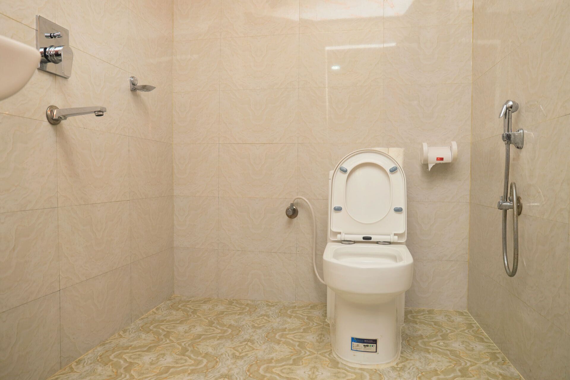 Une petite salle de bain moderne équipée de toilettes, d’une douche et d’un robinet mural.