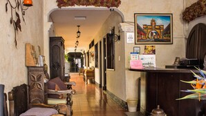 Un'hall d'hotel con arredi in legno, una reception e un quadro appeso al muro.