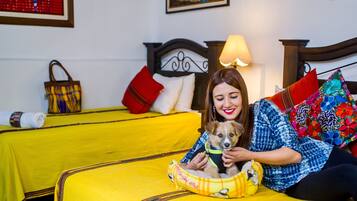 A bed with a yellow bedspread, a wooden headboard, and a lamp.