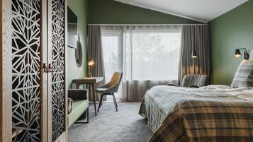 TvÄbÀddsrum Hotellhus | VÀrdeförvaringsskÄp pÄ rummet, skrivbord och arbetsyta för laptop