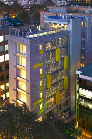 Un bâtiment moderne à plusieurs étages, doté de grandes fenêtres et d’une terrasse sur le toit.