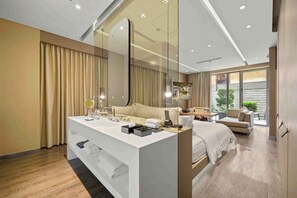 Une chambre d’hôtel moderne dotée d’un grand miroir, d’une coiffeuse blanche, d’un lit, d’un canapé et offrant une vue sur l’extérieur.