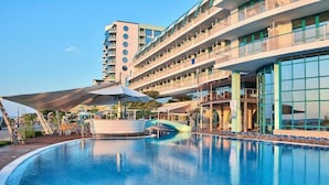 A hotel with a swimming pool, outdoor seating, and a multi-story building with balconies. - Berlin Golden Beach Hotel (Golden Sands)