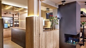 Un interior moderno con detalles de madera, una recepción y un televisor montado en la pared.