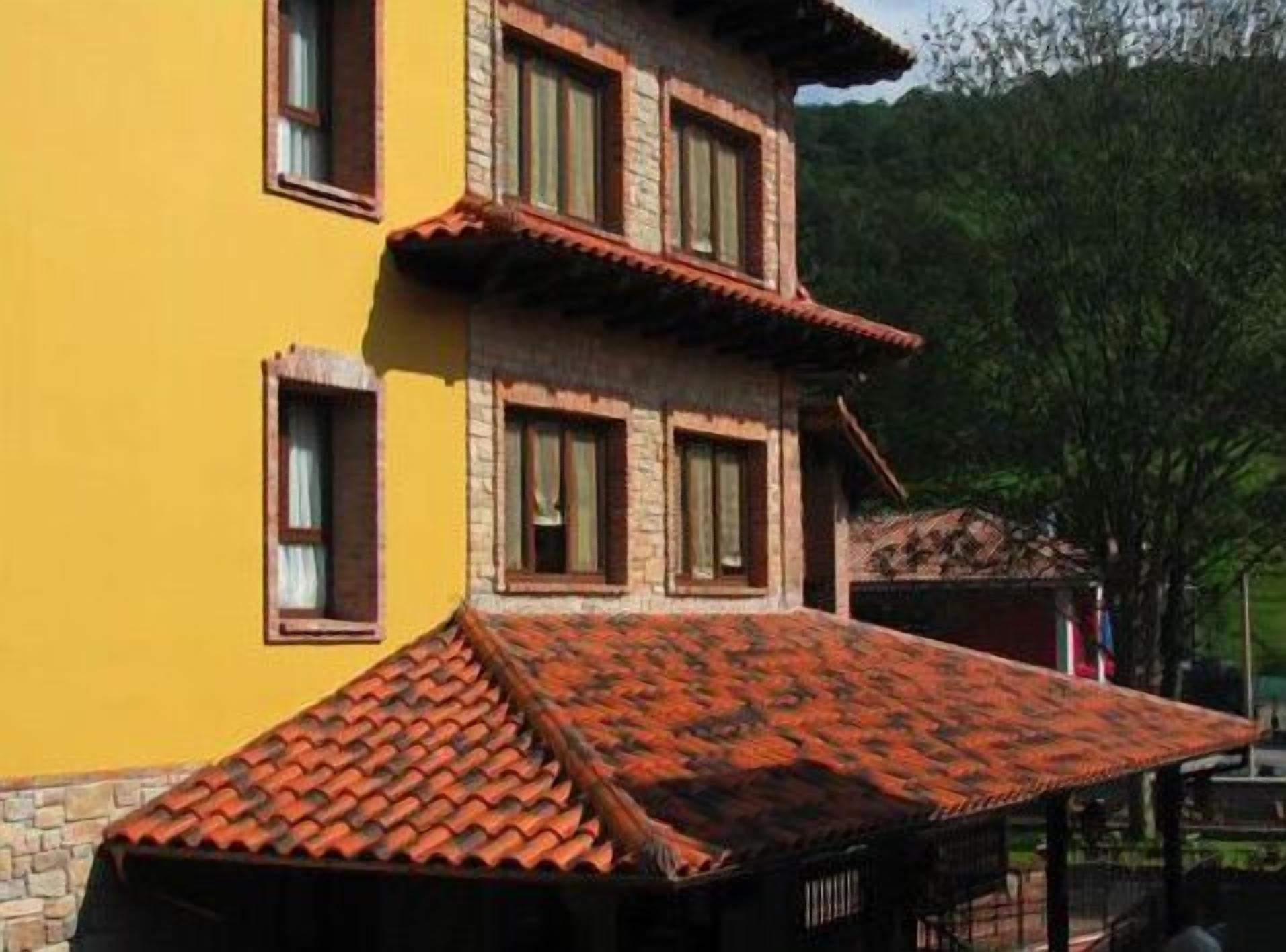 A two-story building with a yellow facade and a red-tiled roof.
