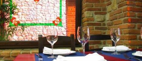 Un restaurante con pared de ladrillo y ventana de marco verde.