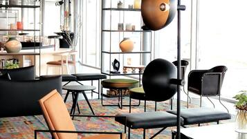 A modern interior with a black sofa, a coffee table, and a patterned rug.
