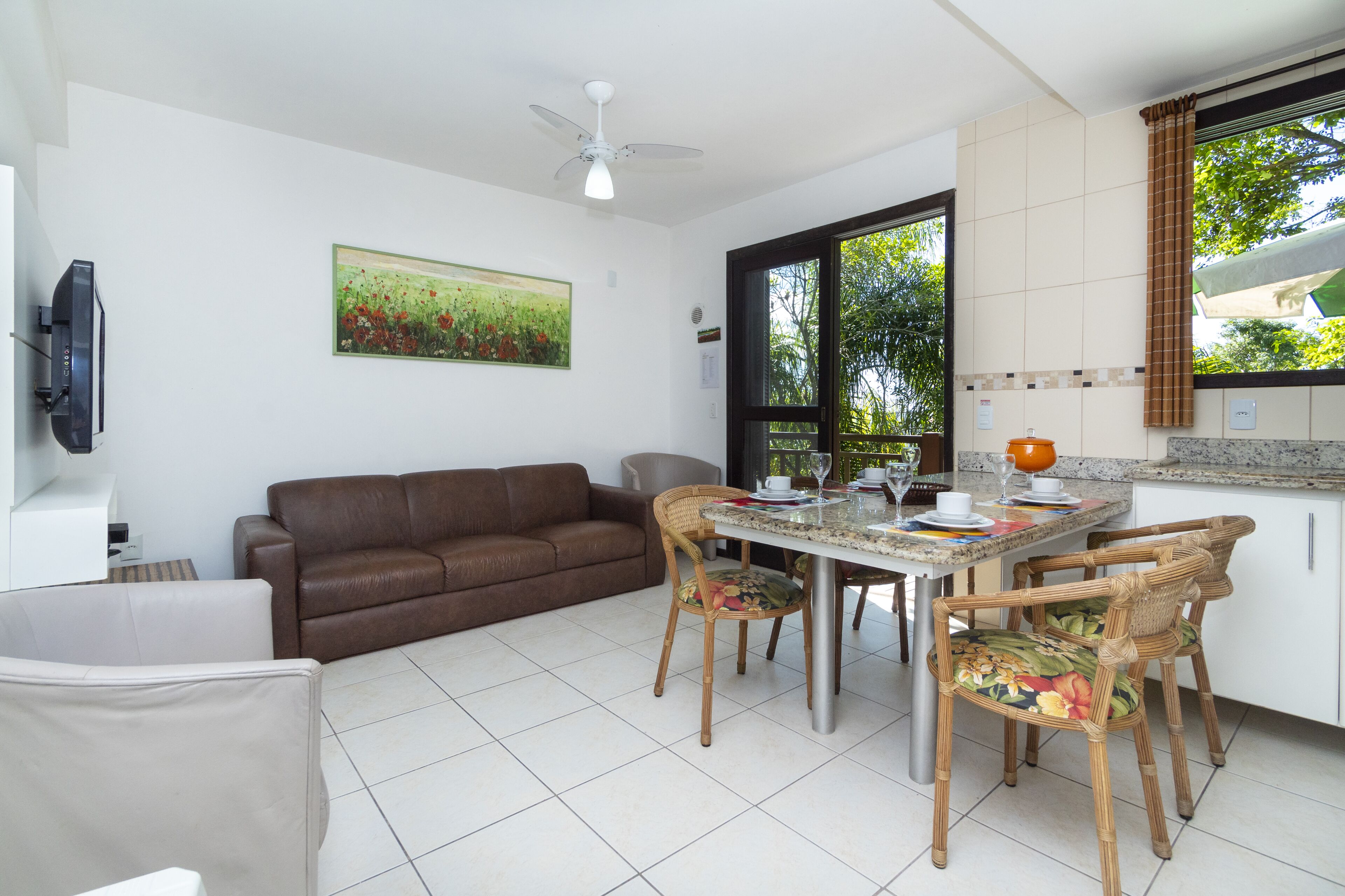 A dining area with a table, chairs, and a ceiling fan.