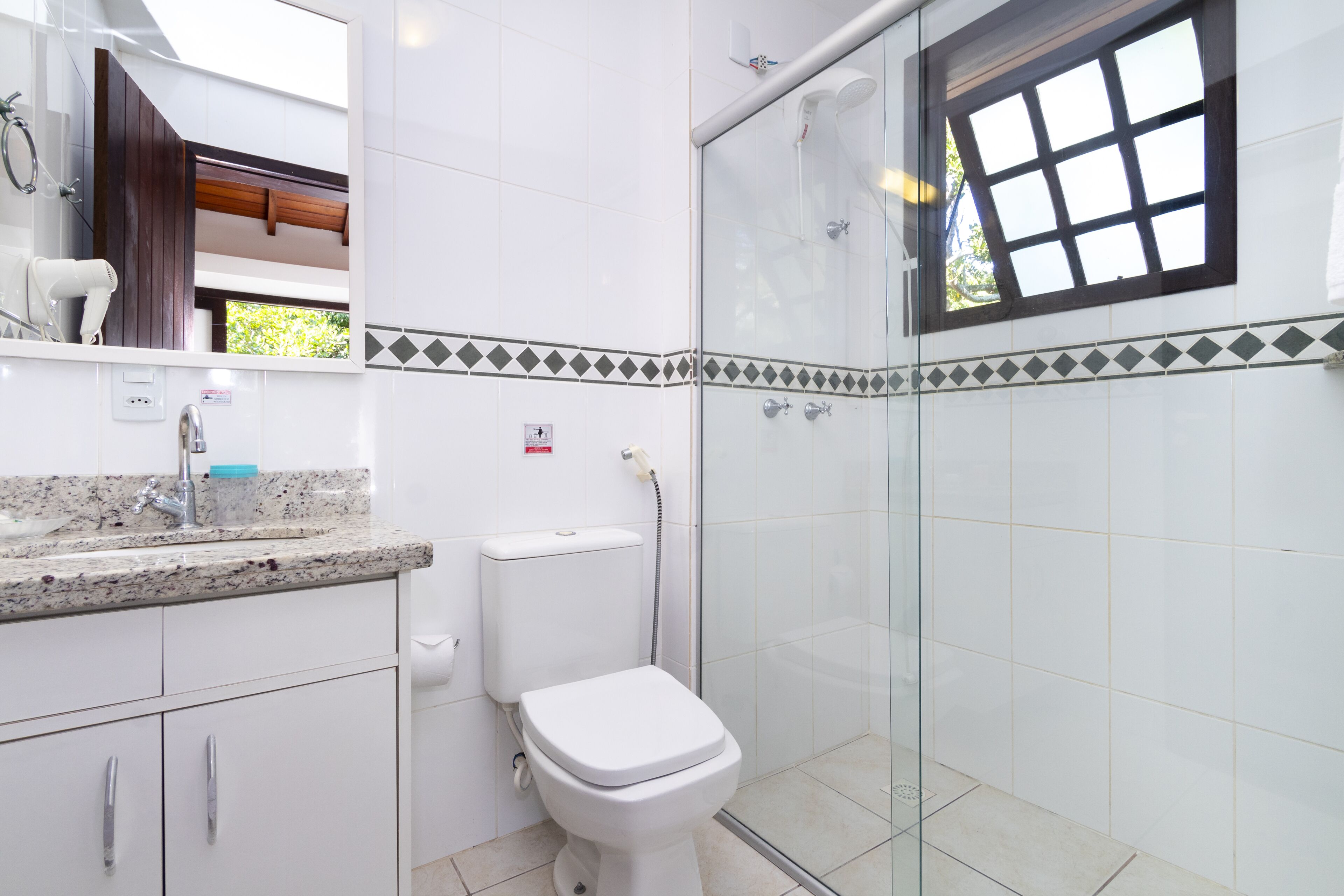 Un baño con inodoro, lavabo y ducha.