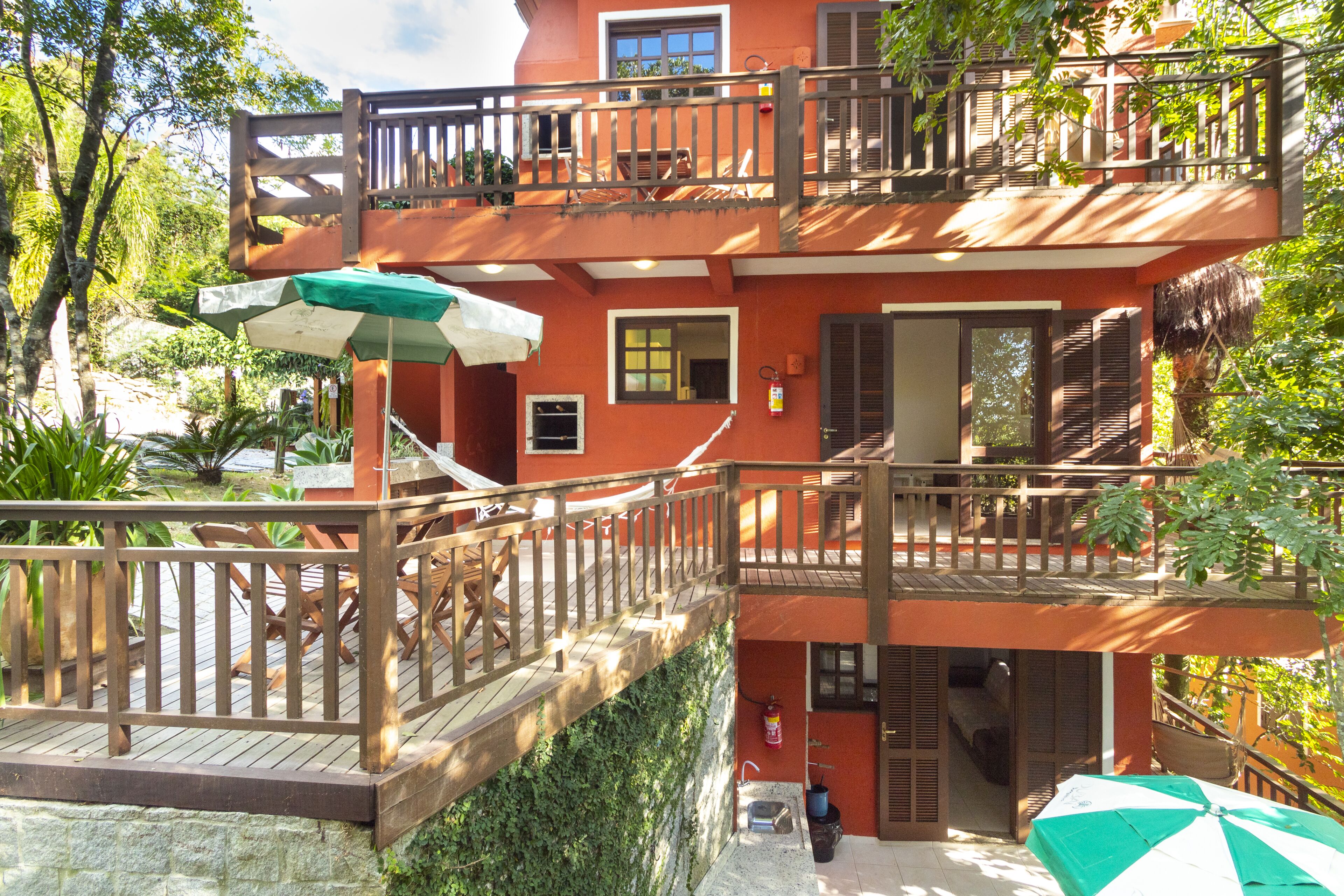A two-story building with a wooden deck and a balcony.