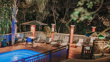 Una piscina al aire libre, sombrillas, sillones reclinables de piscina