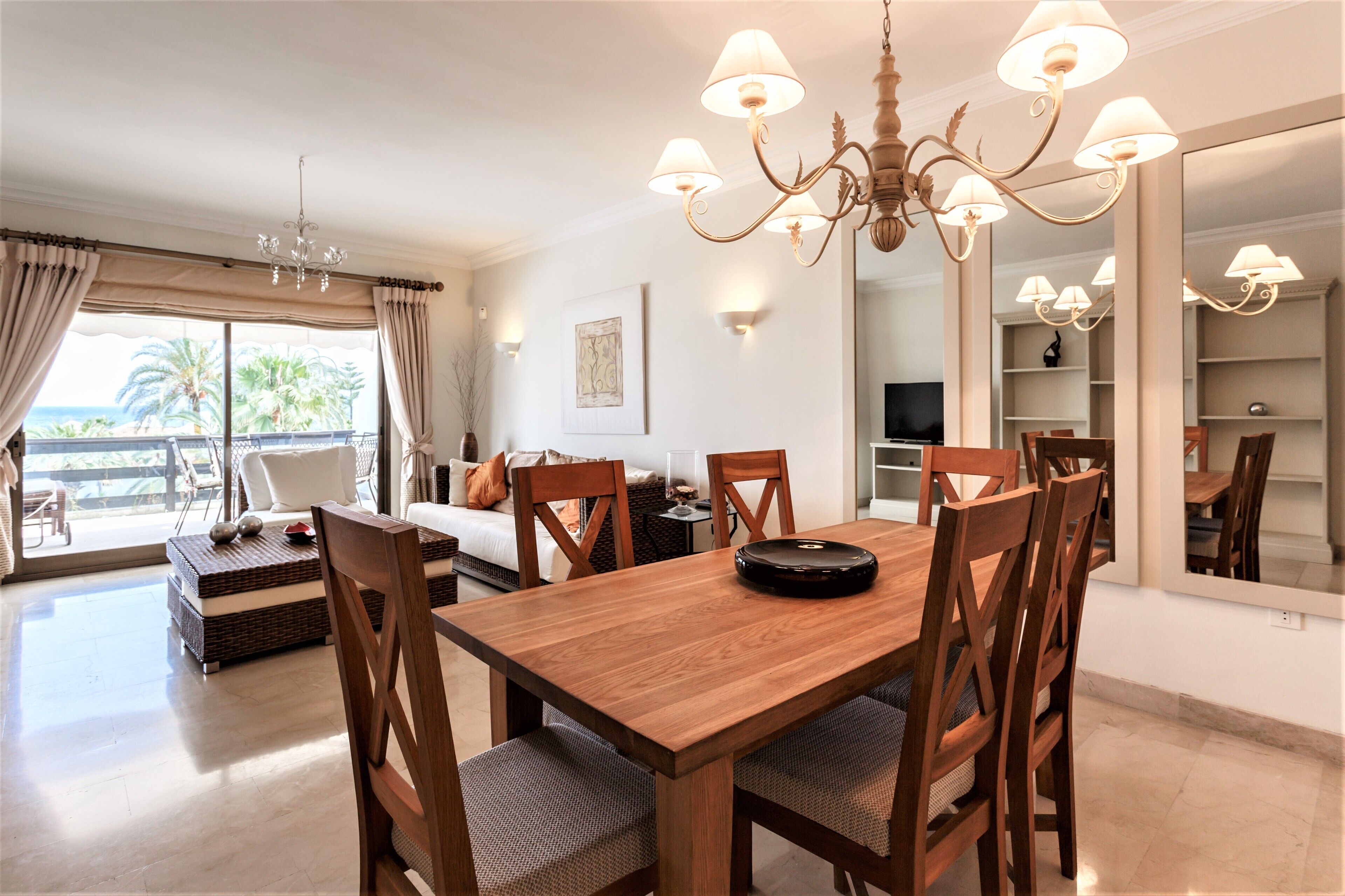 A dining area with a wooden table, chairs, and a chandelier.