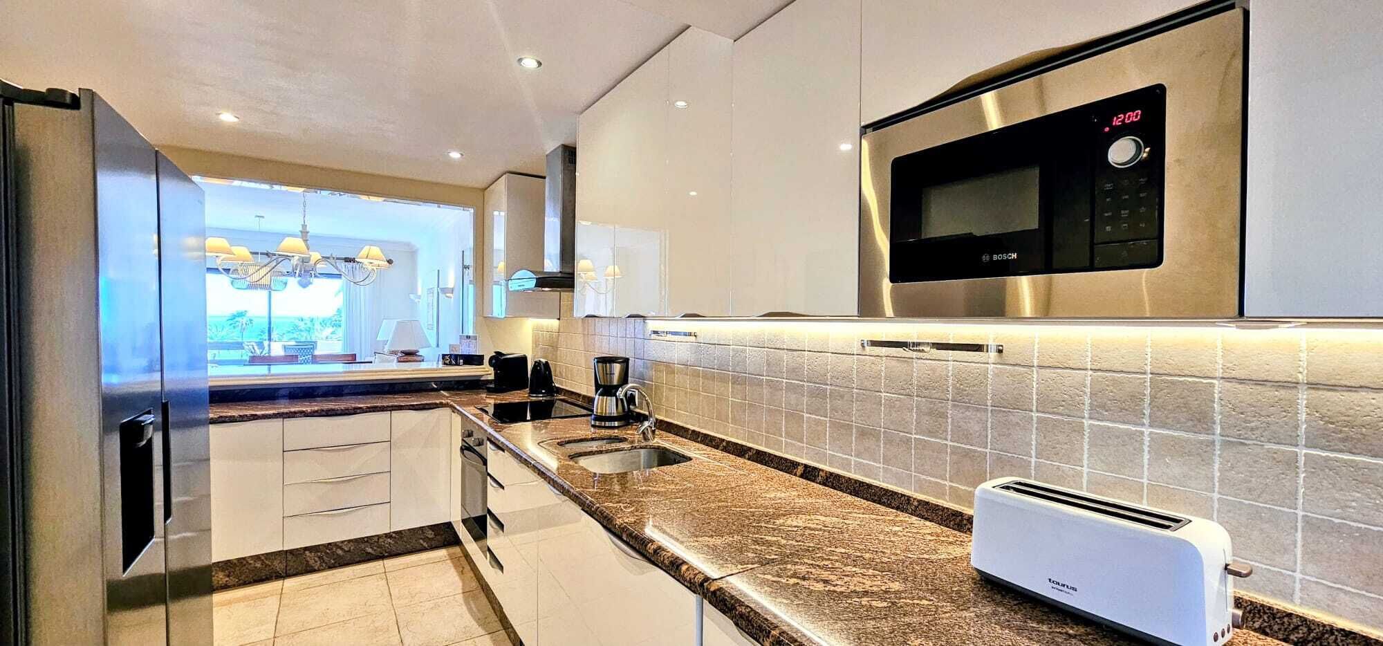 Eine moderne Küche mit integriertem Mikrowellenherd, einer Kaffeemaschine und einem Toaster.